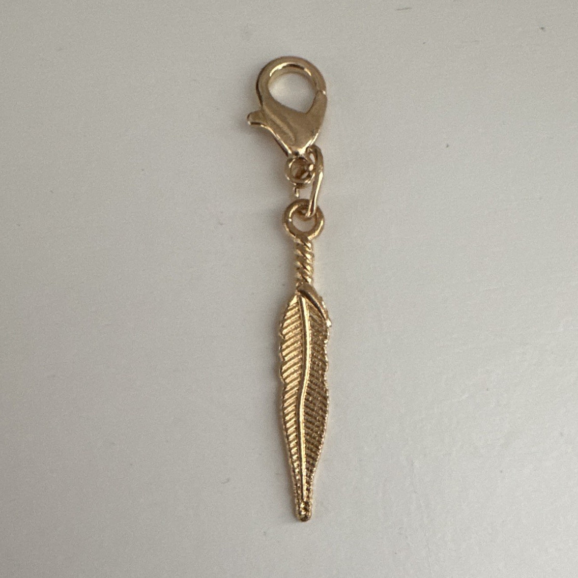 gold tone feather dangle charm lobster clasp nature metal no stone