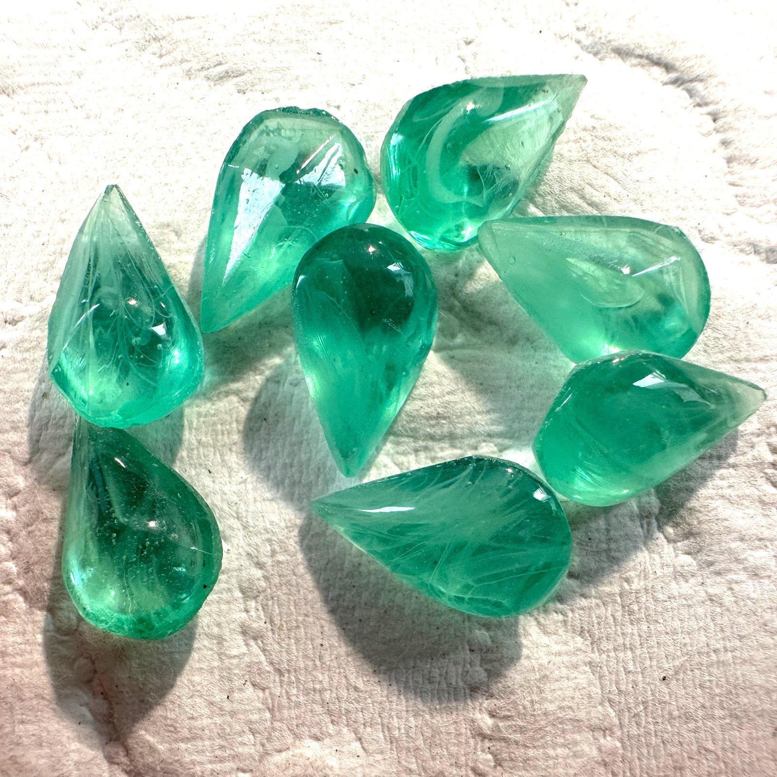 AM1316 Vintage glass pears 13x8mm lt. emerald “flawed” cab top faceted back (8)