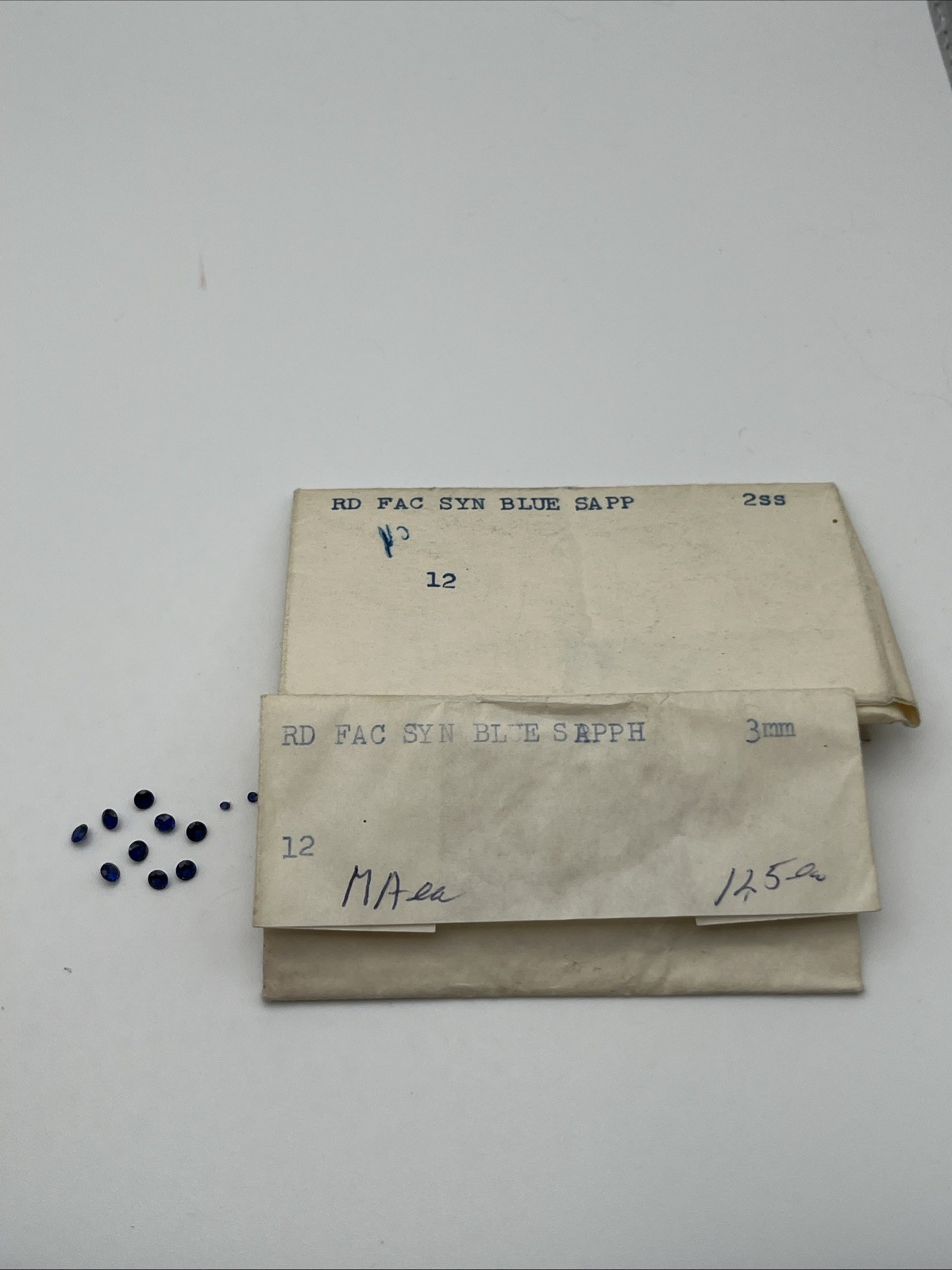 Nine 3 Mm And Three 1.5 Mm Round Faceted Synthetic Blue Sapphires