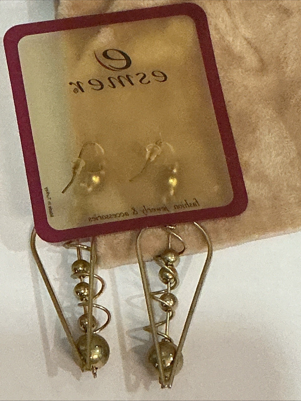 Esmer brand gold-tone dangle earrings feature a distinctive geometric triangle